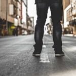Una persona esta de espaldas en la calle, mostrando solamente sus pies en el Bronx.