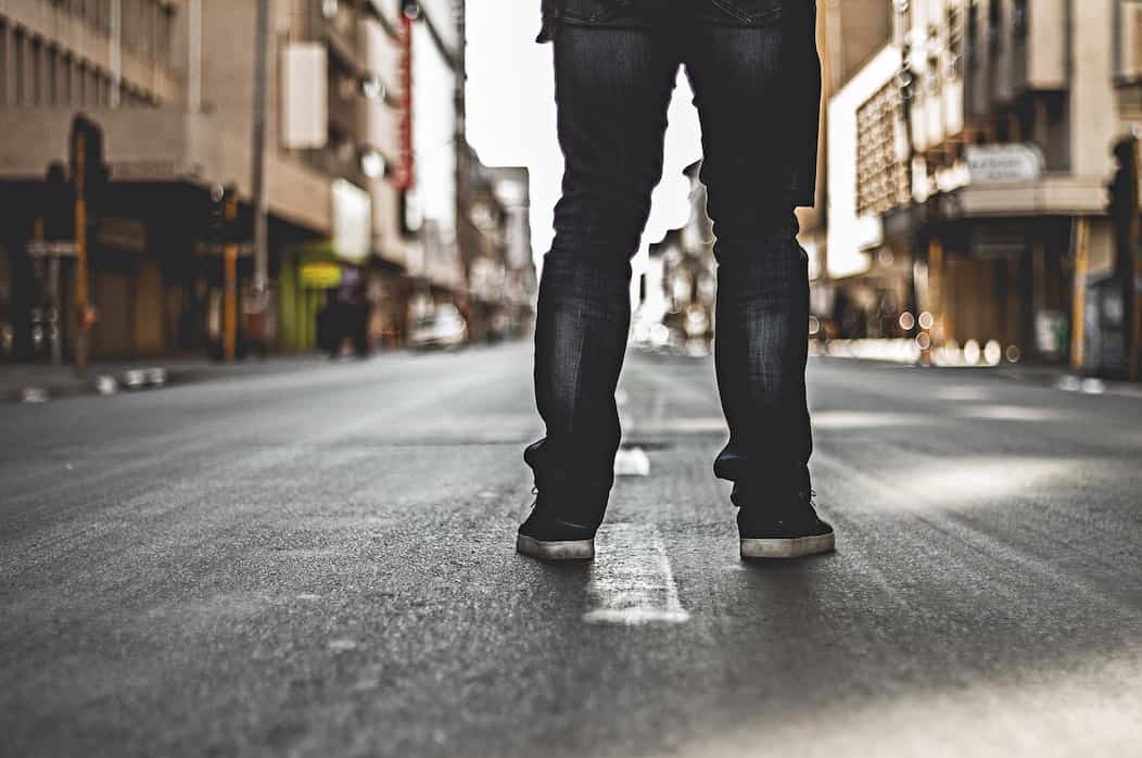Una persona esta de espaldas en la calle, mostrando solamente sus pies en el Bronx.