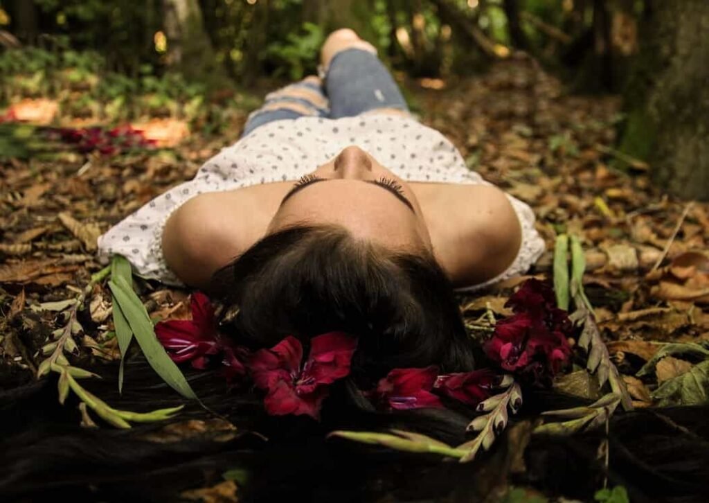 Mujer en el bosque acostada.