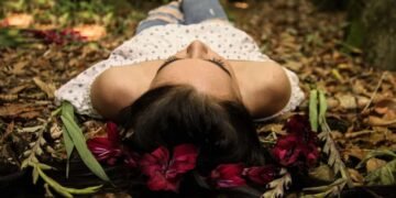 Mujer en el bosque acostada.