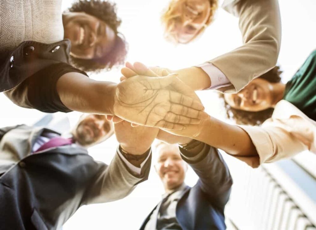 Personas en grupo mirando hacia a bajo con las manos cruzadas en el Tedx Bogotá.