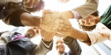 Personas en grupo mirando hacia a bajo con las manos cruzadas en el Tedx Bogotá.