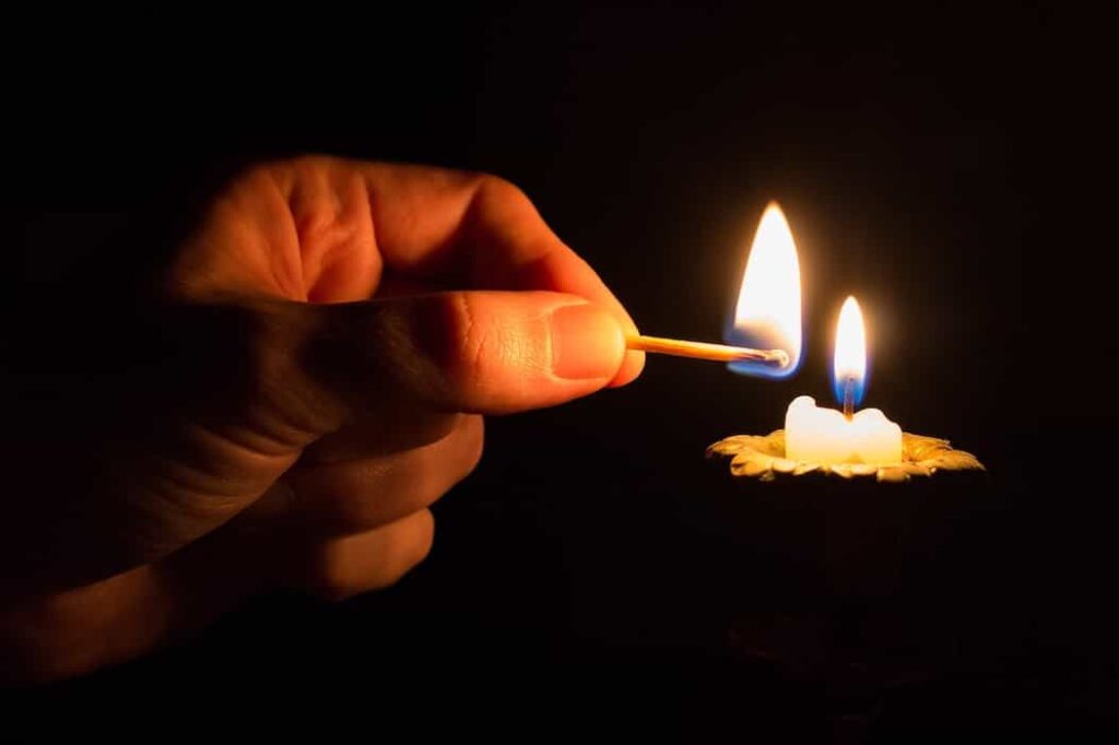 Una persona esta sin luz en su casa, se ve su mano tratando de prender una vela en este corte de luz en Cundinamarca.