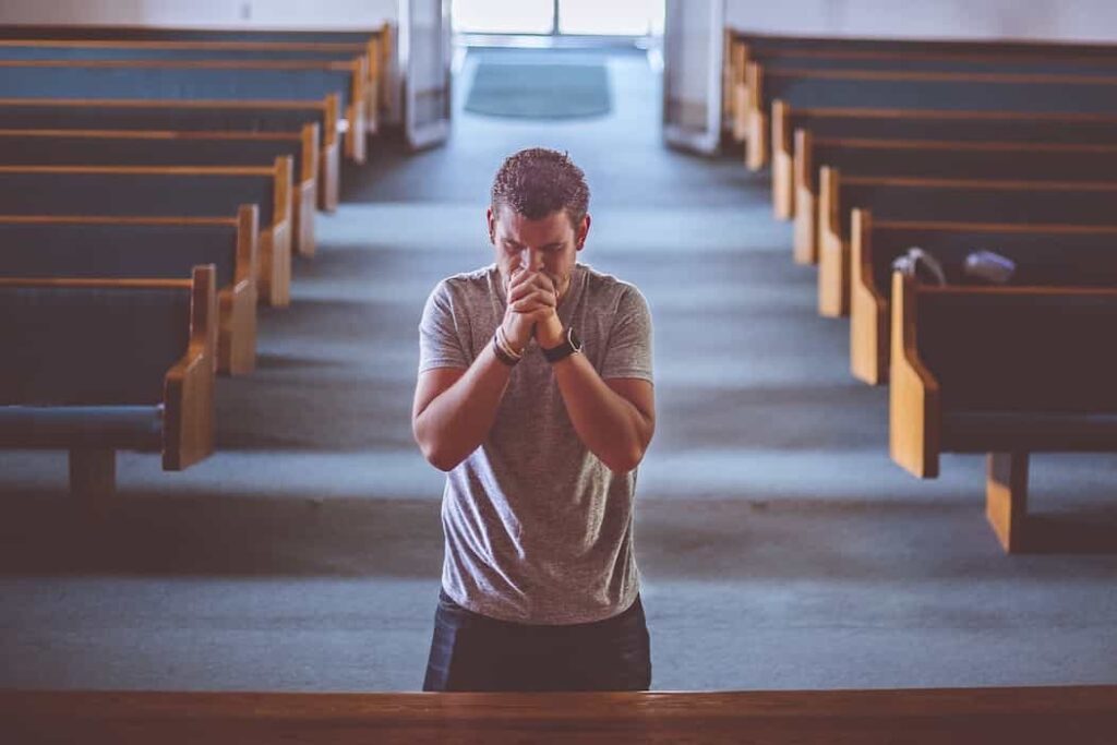 En la iglesia se encuentra un hombre resando, visitando las principales iglesias en la ruta vive Cundinamarca religiosa.