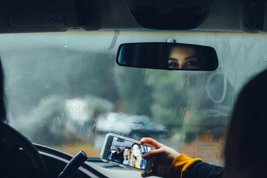 Una mujer en un carro tomándose una fotografía selfie en medio del pico y placa en semana santa.