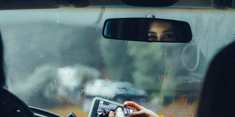 Una mujer en un carro tomándose una fotografía selfie en medio del pico y placa en semana santa.