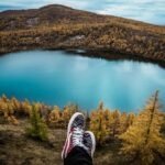 Viajando esta una personas solo mostrando sus zapatos en una laguna azul representando la laguna de guatavita en Cundinamarca.