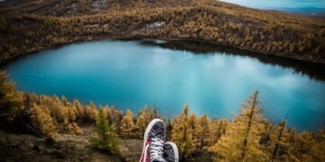 Viajando esta una personas solo mostrando sus zapatos en una laguna azul representando la laguna de guatavita en Cundinamarca.
