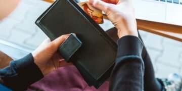 una mujer con su cartera y su tarjeta de crédito dinero a tu negocio.