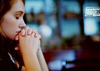 Una mujer esta orando con los ojos cerrados