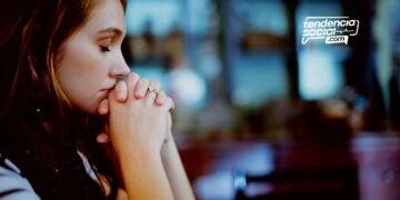 Una mujer esta orando con los ojos cerrados