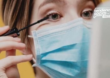 Mujer se esta mirando al espejo, usando el tapabocas.