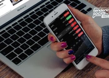 Una persona con su celular y su computador mirando la lista de bonos.