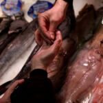 Una persona compra pescado.