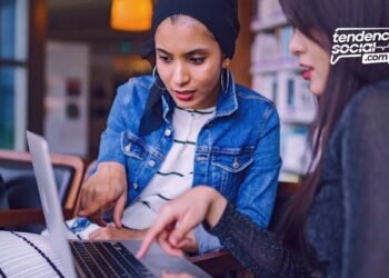 Dos mujeres están viendo el computador en un escritorio