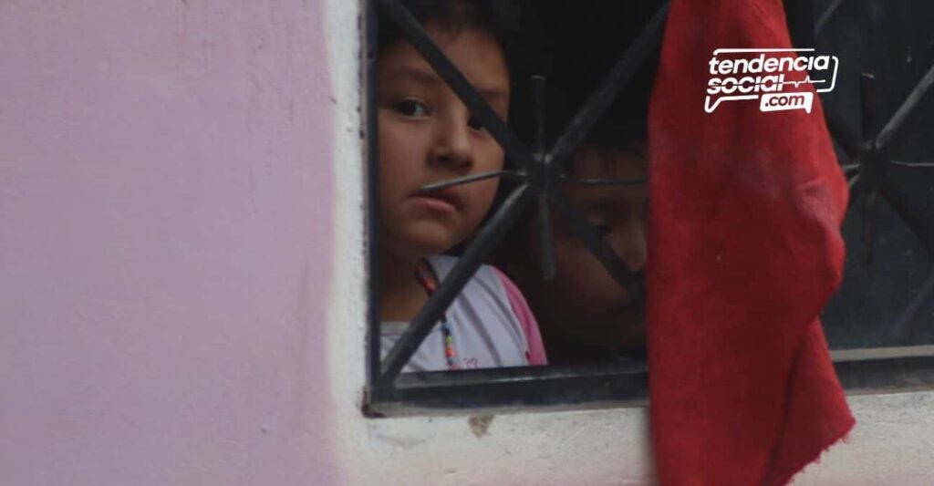 Una persona alzando la mano y agarrando en una ventana un trapo rojo