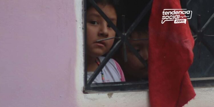 Una persona alzando la mano y agarrando en una ventana un trapo rojo