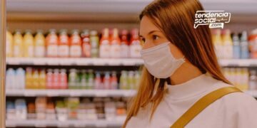 Una mujer esta en un supermercado comprando productos