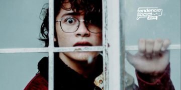 Un hombre esta mirando por la ventana sorprendido