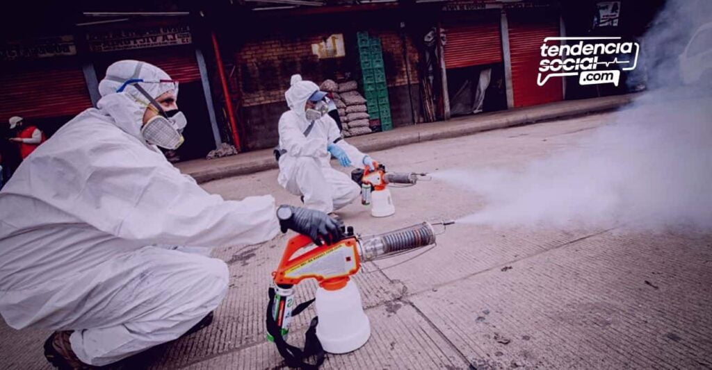 Dos personas están fumigando las calles de los negocios que cierran en corabastos