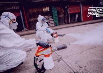 Dos personas están fumigando las calles de los negocios que cierran en corabastos