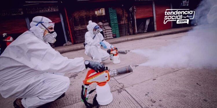 Dos personas están fumigando las calles de los negocios que cierran en corabastos