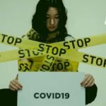 Una mujer rodeada de cintas que dicen stop del covid-19