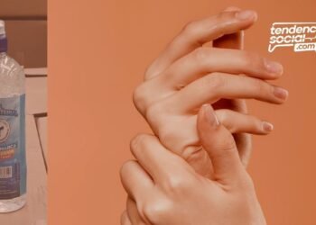 Una botella anti bacterial en alcohol de la licorera de Cundinamarca y unas manos frotándose la piel.