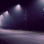 Una calle en la oscuridad y una persona a lo lejos.