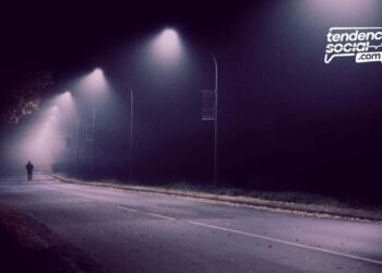 Una calle en la oscuridad y una persona a lo lejos.