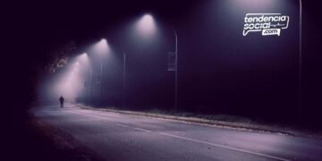 Una calle en la oscuridad y una persona a lo lejos.