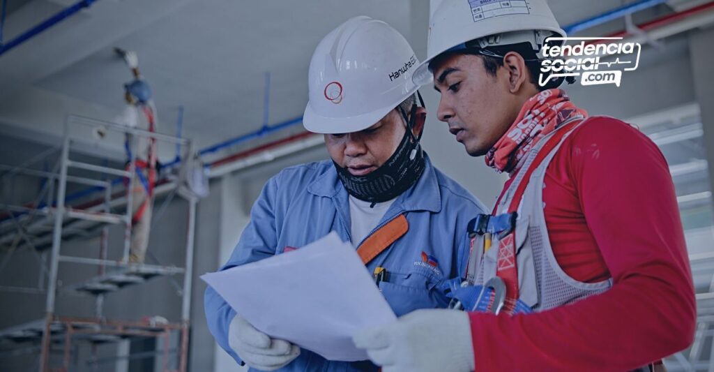 Dos hombres trabajando en construcción y mirando unos document