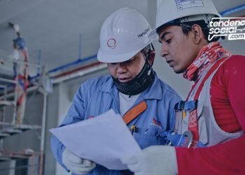 Dos hombres trabajando en construcción y mirando unos document