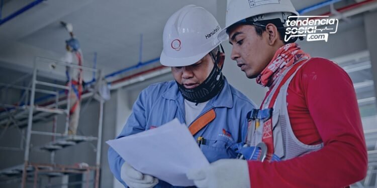 Dos hombres trabajando en construcción y mirando unos document