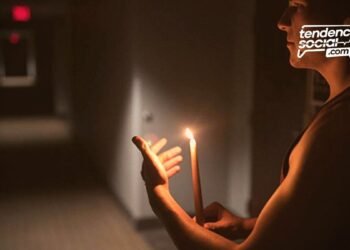 Un hombre en su casa con una vela, por cortes de luz en Soacha