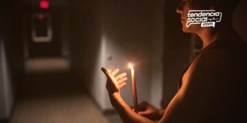 Un hombre en su casa con una vela, por cortes de luz en Soacha