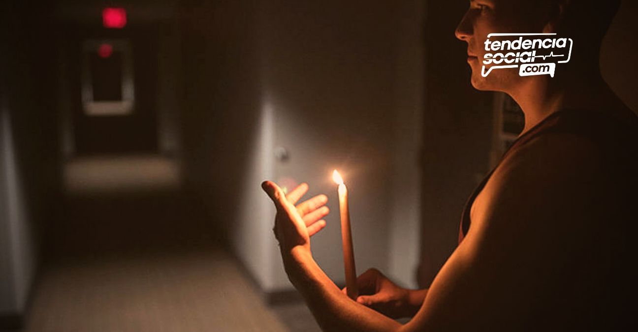 Un hombre en su casa con una vela, por cortes de luz en Soacha