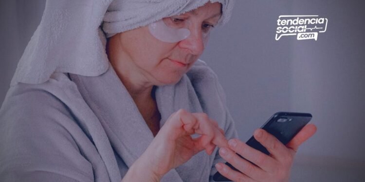 Una mujer mayor de edad mirando el celular.