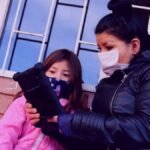 Una niña y una señora están viendo su tableta educativa
