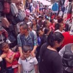 comercio y vendedores ambulantes en la calle 13 de Soacha, personas venden productos y la gente esta pasando por el corredor.