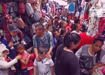 comercio y vendedores ambulantes en la calle 13 de Soacha, personas venden productos y la gente esta pasando por el corredor.