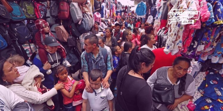 comercio y vendedores ambulantes en la calle 13 de Soacha, personas venden productos y la gente esta pasando por el corredor.
