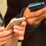 Dos personas textiando y mirando el celualar ayuda soacha mensajes falsos para reclamar ayuda