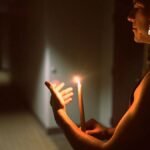 Un hombre esta con una vela en su casa en Soacha por cortes de luz