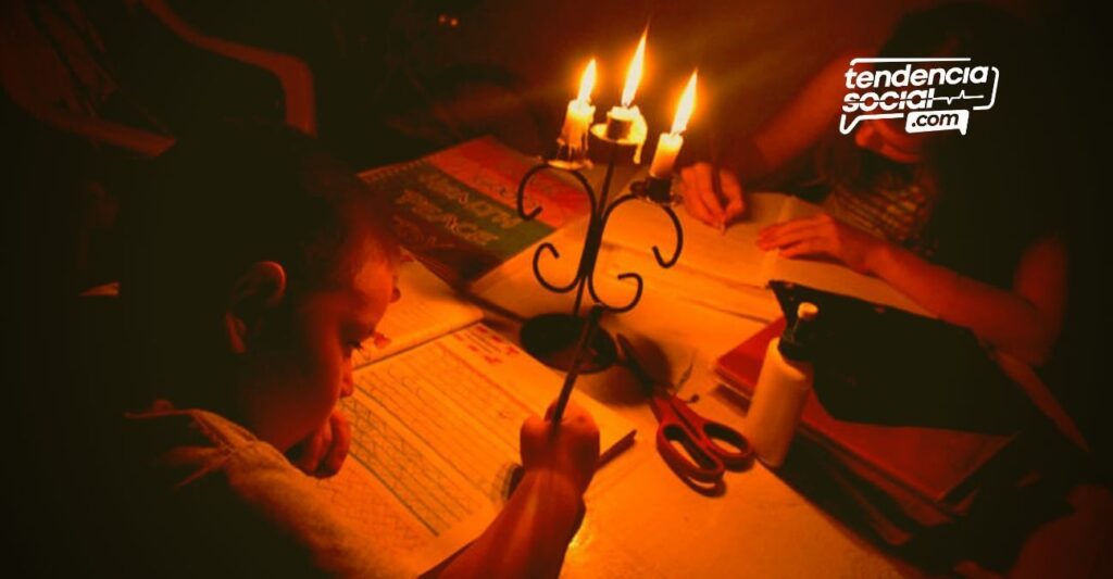 Un niños haciendo tareas en la mesa en medio de unas velas sin luz en Soacha y en la casa