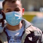 Un señor con tapabocas en la calle de Bogotá hablando por teléfono