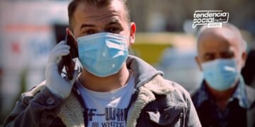 Un señor con tapabocas en la calle de Bogotá hablando por teléfono