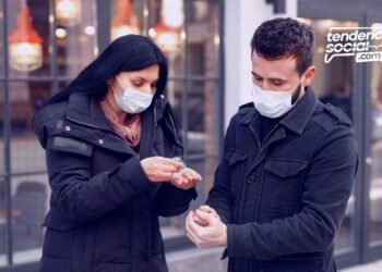 Una pareja hombre y mujer en la calle aplicándose alcohol
